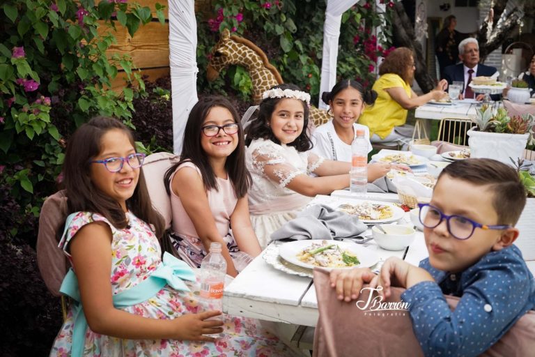 Fotografía profesional de familia a la mesa en evento de primera comunión